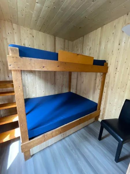 Un lit superposé en bois est installé dans l'une des chambres du chalet 9.