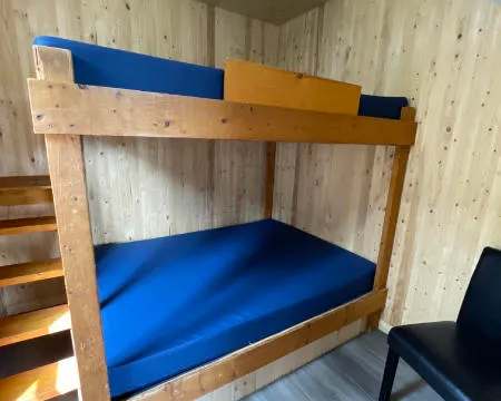 Un lit superposé en bois est installé dans l'une des chambres du chalet 9.