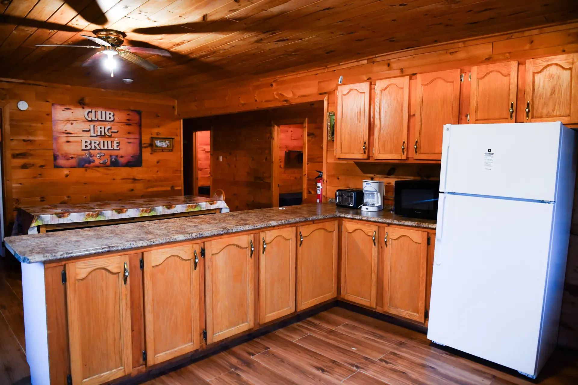 The cottage's fully equipped kitchen features wooden cabinets, a refrigerator, and a functional counter.