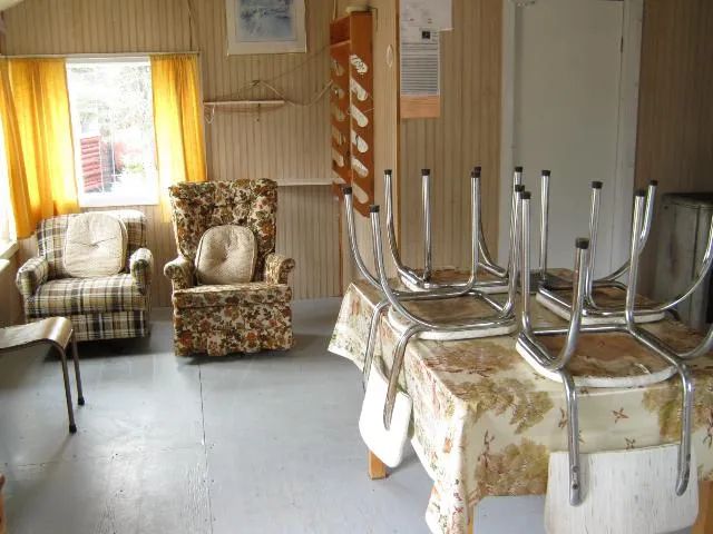 View of the cabin's main living area, featuring armchairs and a dining table.