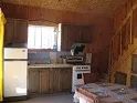 View of the equipped kitchen and dining table on the ground floor of the cottage.