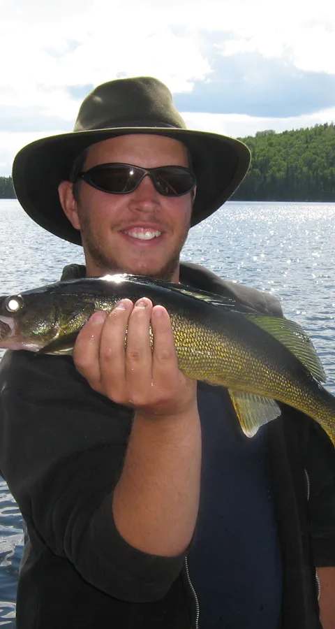 Angler proud of his catch on the boat at Club Principal - l'Aventurier, Mauricie, Quebec