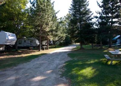 Vue sur les emplacements de camping entourés d'arbres pour les véhicules récréatifs.
