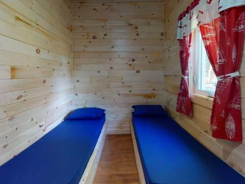 Cette chambre du chalet Martin comprend deux lits simples avec une finition en bois naturel.