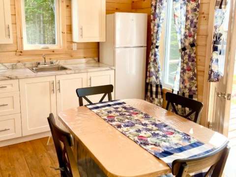 La cuisine fonctionnelle du chalet comprend une table à manger et des appareils électroménagers.