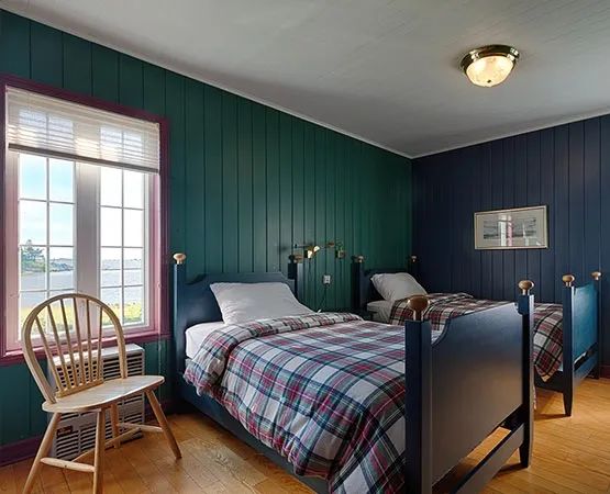 This bedroom in the main house features two single beds with a view of the outdoors.