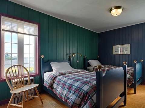 This bedroom in the main house features two single beds with a view of the outdoors.