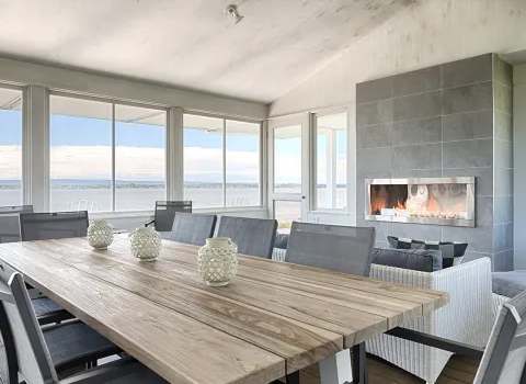 The bright dining room of the main house offers a panoramic view of the water.