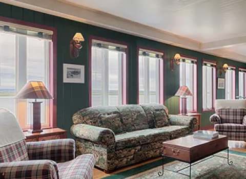 The main house features a bright living area with a lounge and a dining room.
