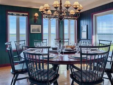The main house dining room features a panoramic view of the water.