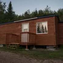 Vue extérieure du chalet Colibri, un hébergement en bois avec une petite galerie.