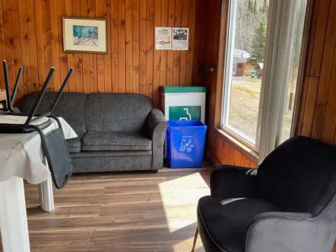 The Colibri cabin living area includes a sofa, an armchair, and a view of the outdoors.