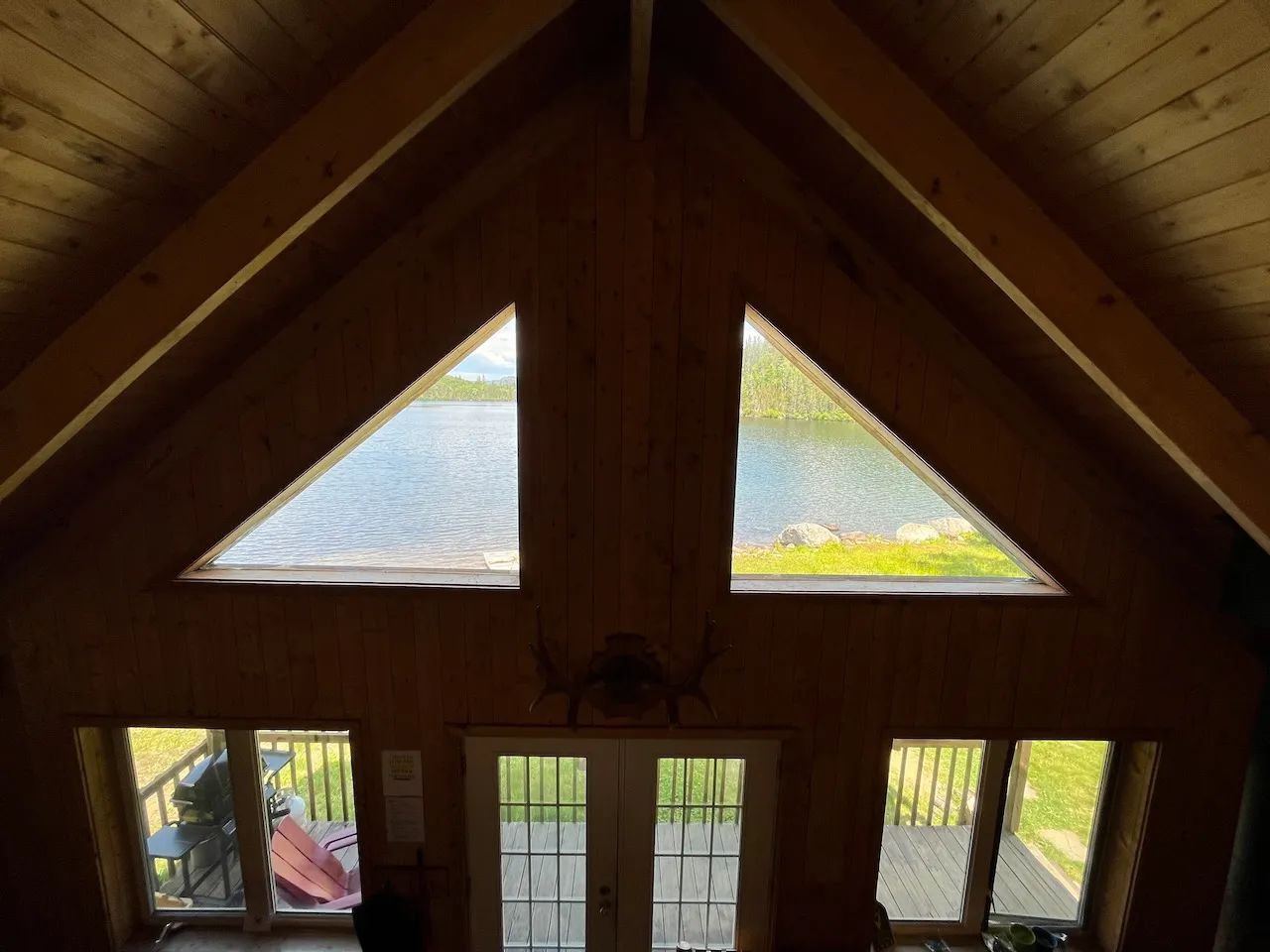 Vue imprenable sur le lac depuis le salon chaleureux du chalet Geai Bleu.