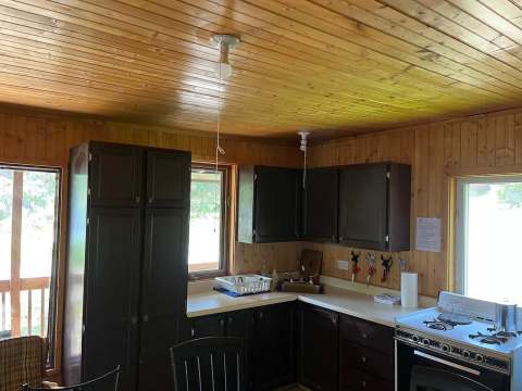 La cuisine équipée du chalet Gélinotte avec ses armoires en bois et sa cuisinière.