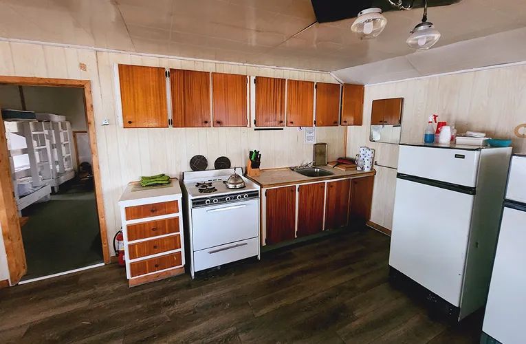 La cuisine équipée du chalet comprend une cuisinière, un réfrigérateur et des espaces de rangement.