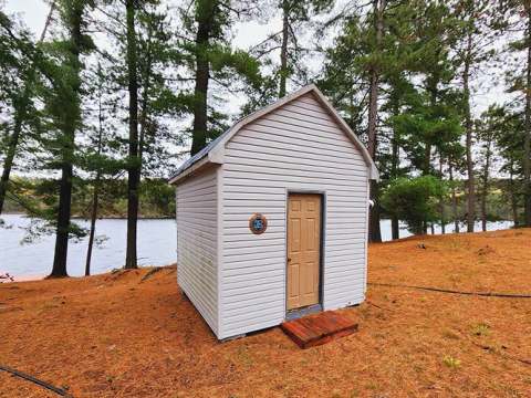 Une vue extérieure du petit chalet #1 situé à proximité immédiate du lac.