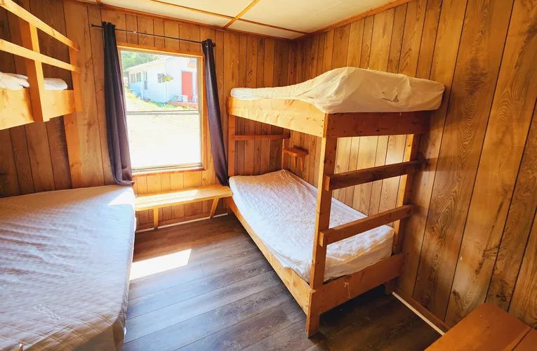 Cette chambre de chalet est équipée de lits superposés en bois.