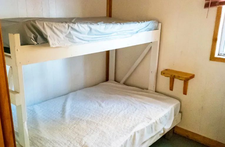 Cette chambre est équipée de lits superposés en bois.