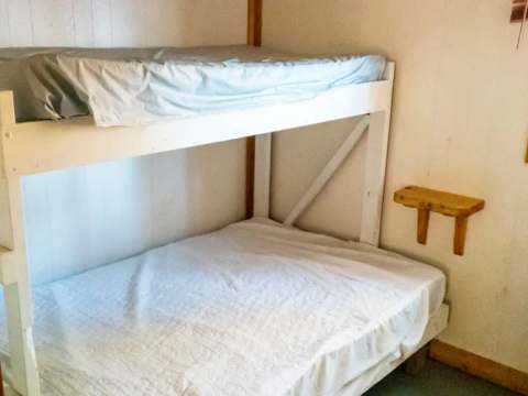 Cette chambre est équipée de lits superposés en bois.