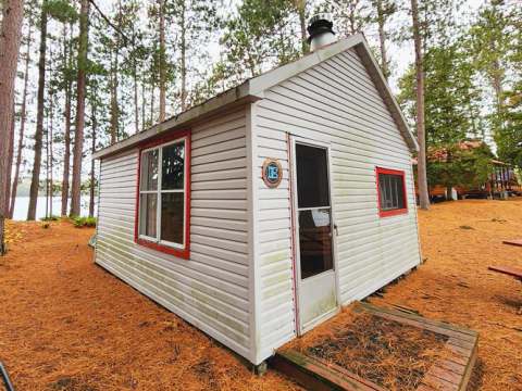 Vue extérieure du chalet numéro quatre situé en forêt près du lac.