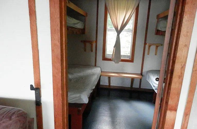 Cette chambre rustique est équipée de lits superposés en bois.