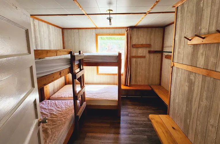 Cette chambre rustique du chalet comprend des lits superposés en bois.