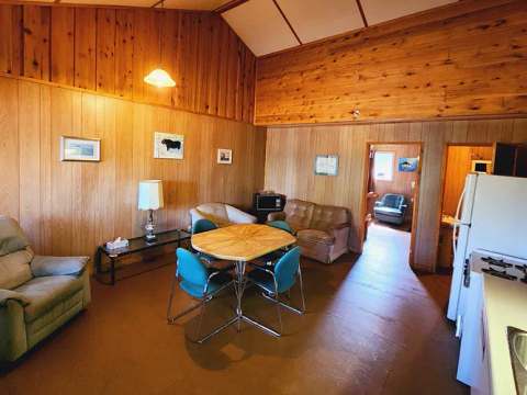 The open area of Suite F includes a functional kitchen, a dining table, and a living room.