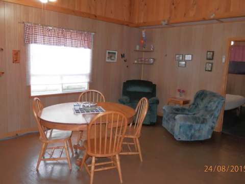 The suite's dining area includes a wooden table and comfortable armchairs.
