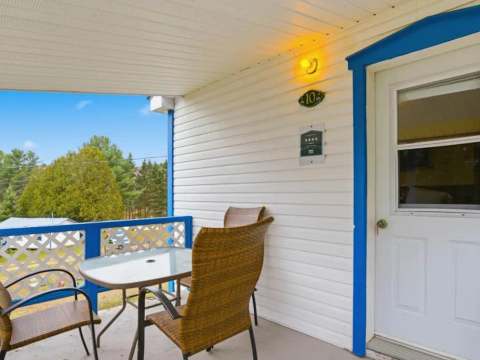 La galerie extérieure du chalet 10 offre un espace de détente avec vue sur la nature.