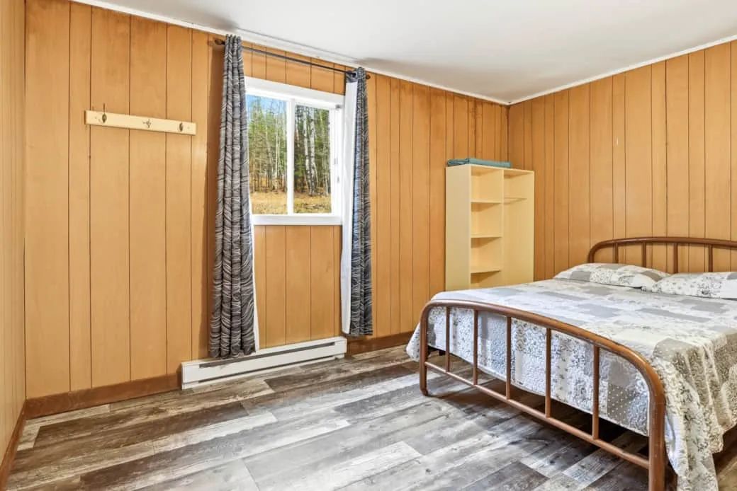 This cottage bedroom features a double bed, storage space, and a window.