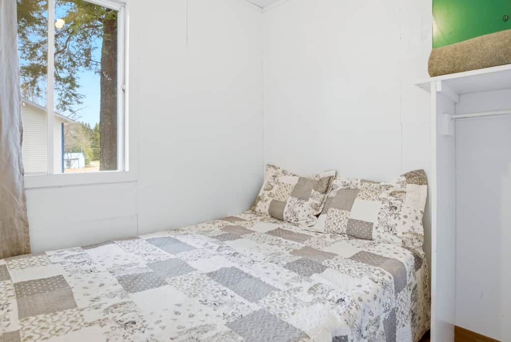 One of the bedrooms in cottage number 15 features a single bed with patterned bedding.