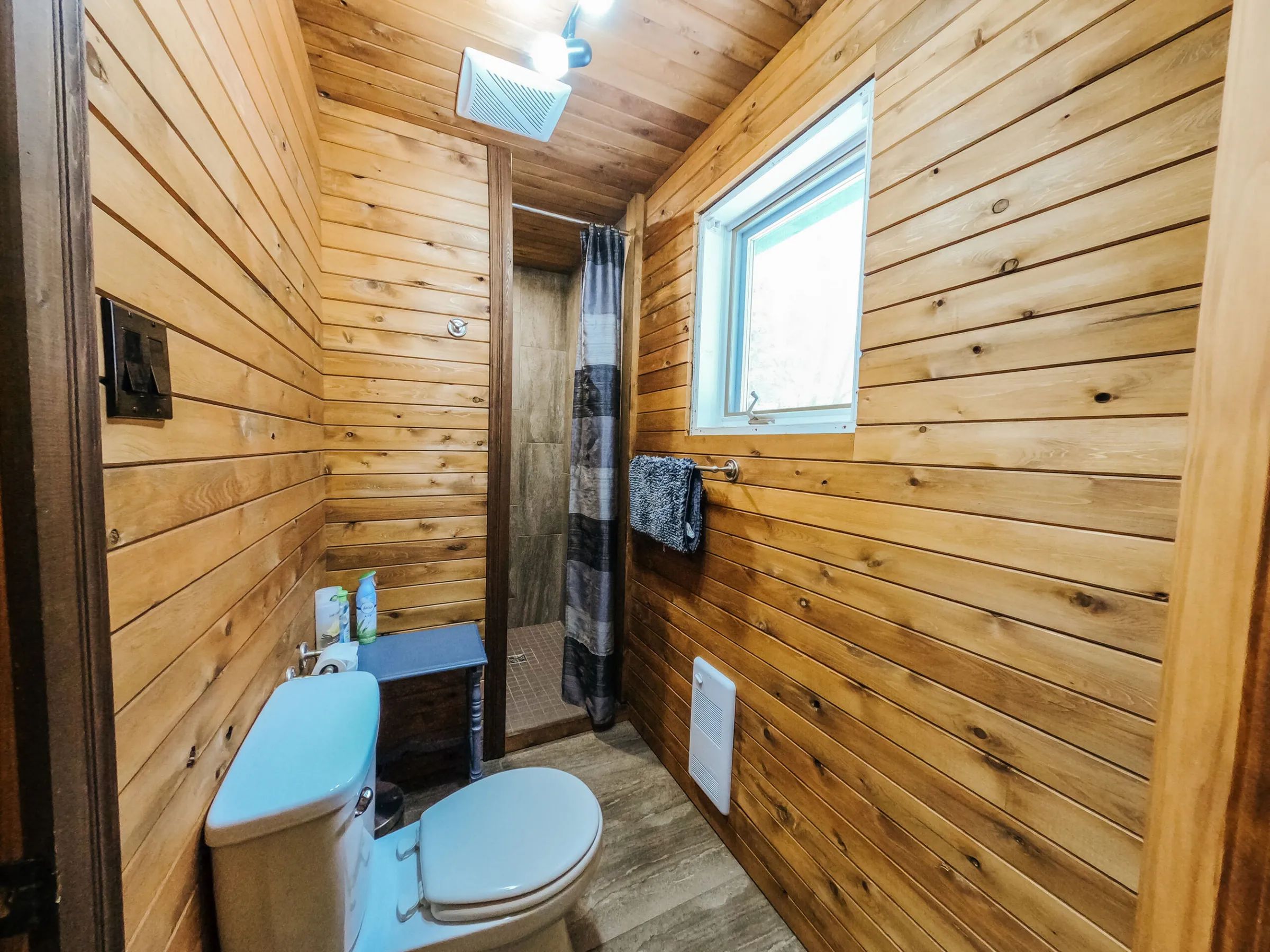 Cette salle de bain fonctionnelle est aménagée avec des murs en lambris de bois.