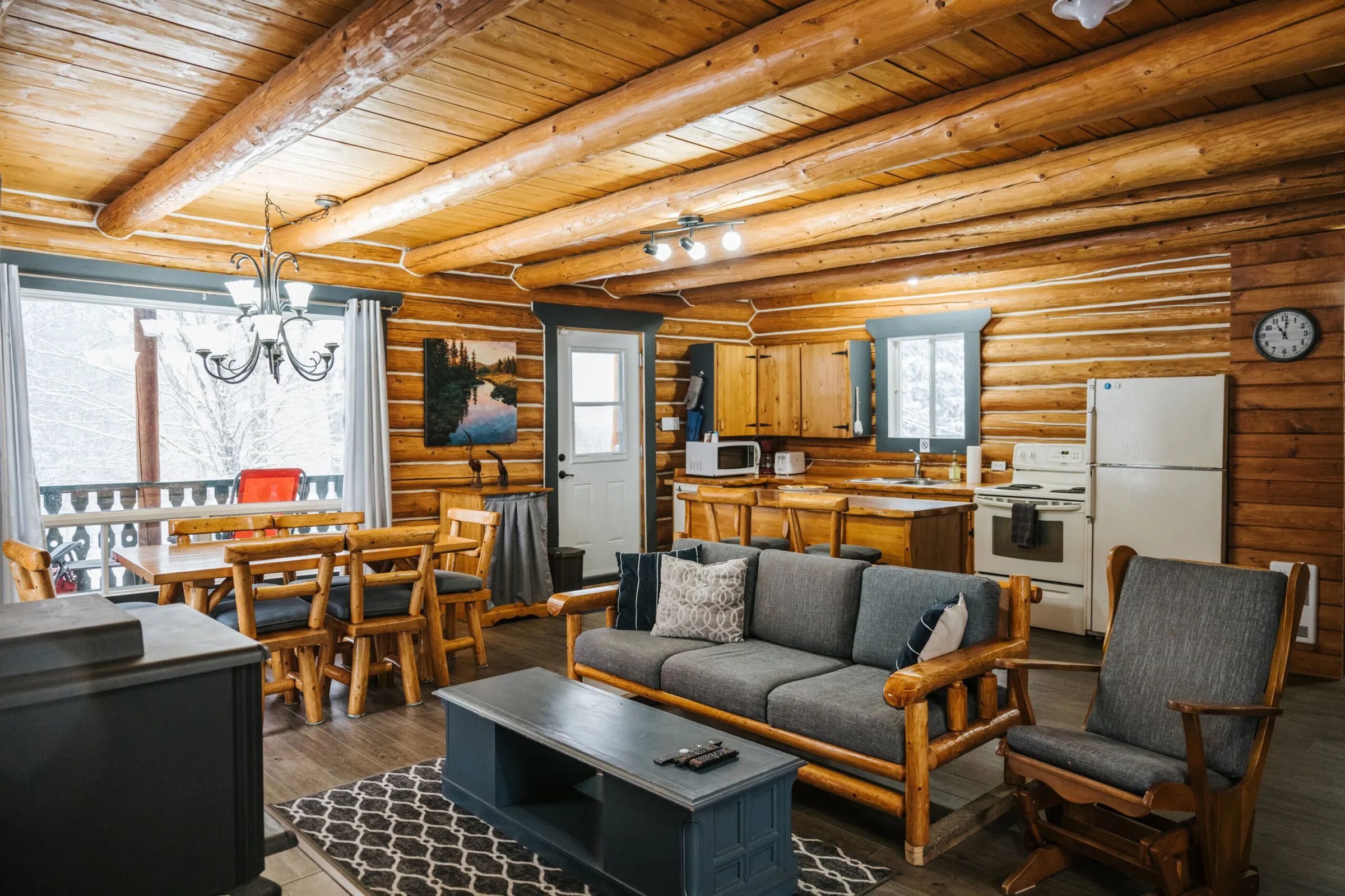 L'aire ouverte du chalet comprend un salon confortable, une salle à manger et une cuisine équipée.