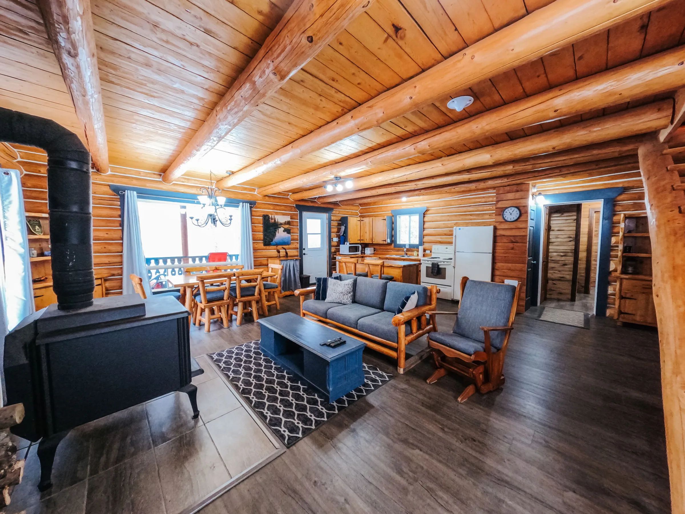 L'intérieur du chalet propose une aire ouverte avec salon, salle à manger et cuisine tout équipée.