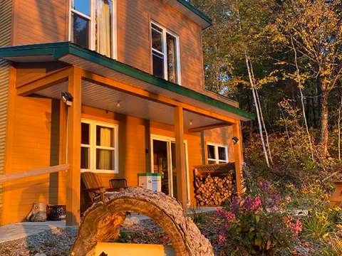 Façade extérieure du chalet Le Mirador à l'heure dorée en automne.