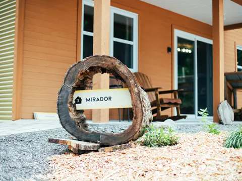 Une enseigne rustique en bois identifie l'entrée du chalet le Mirador.