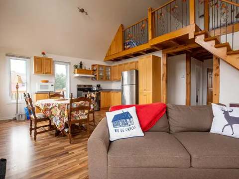 View of the open living area including the living room, kitchen, and dining room of the cabin.