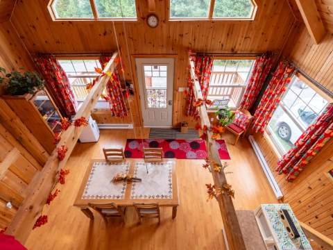 High-angle view of the open-concept living area and bright dining room of Les Lucioles cottage.