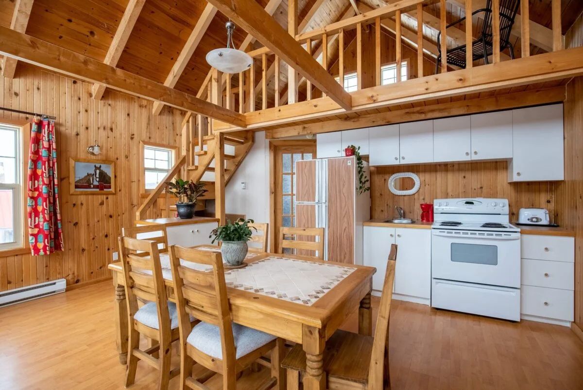 The open-concept area of the Les Lucioles cottage includes a kitchen and a cozy dining room.