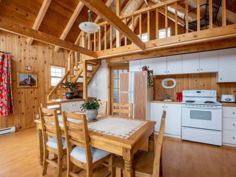The open-concept area of the Les Lucioles cottage includes a kitchen and a cozy dining room.