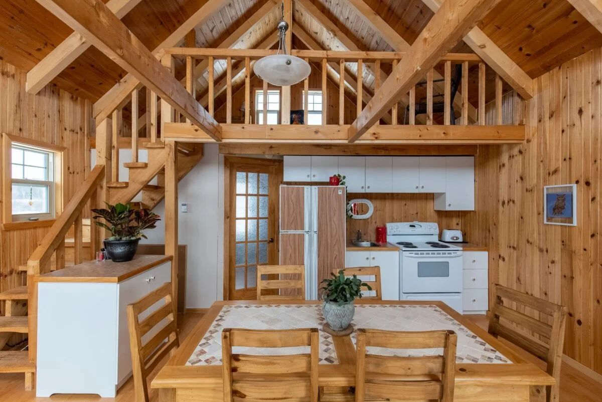 The open-concept cabin features a fully equipped kitchen, a dining area, and a mezzanine.