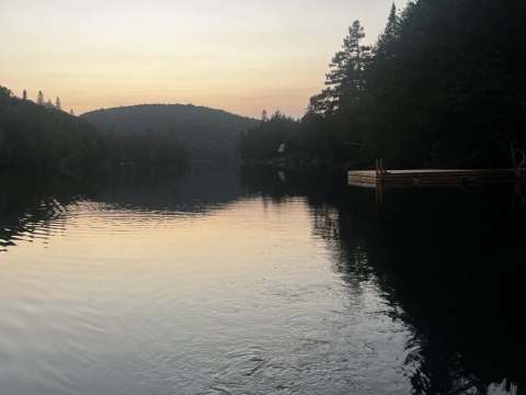 The dock at Le Cerf cabin offers a peaceful view of the lake at sunset.