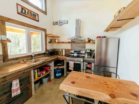 The cottage's equipped kitchen features a stove and a natural wood dining table.