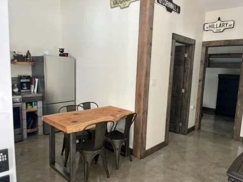 Dining area with wooden table and access to bedrooms at Le Martin pêcheur cottage.