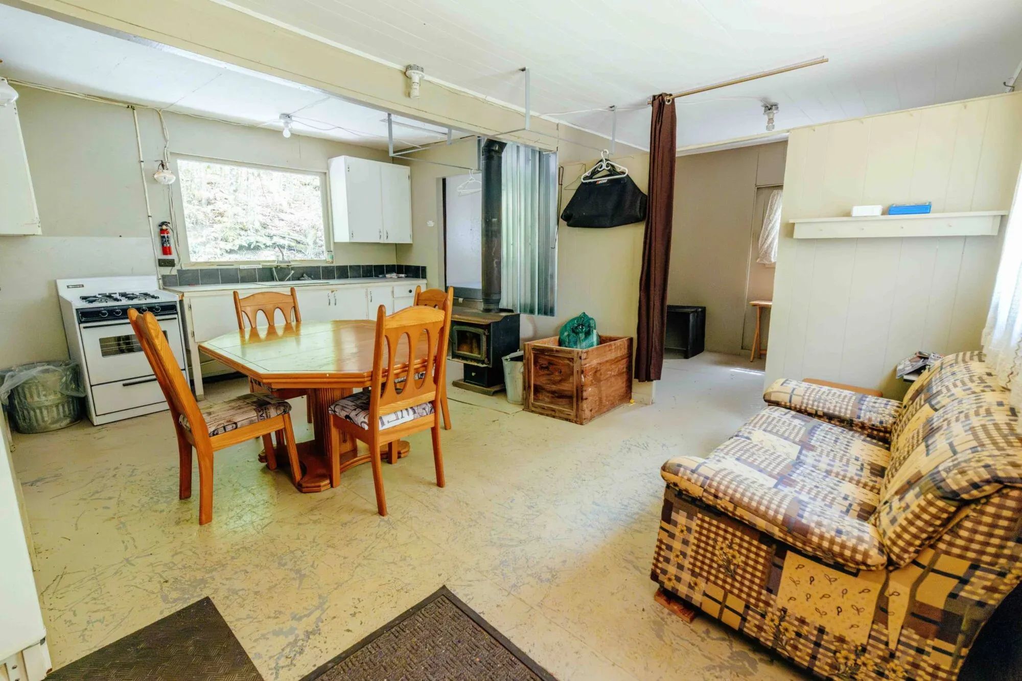 The open area of Le Panache cabin includes a functional kitchen, a dining table, and a sofa.