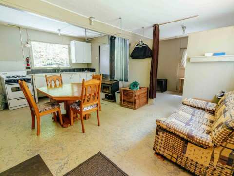 The open area of Le Panache cabin includes a functional kitchen, a dining table, and a sofa.