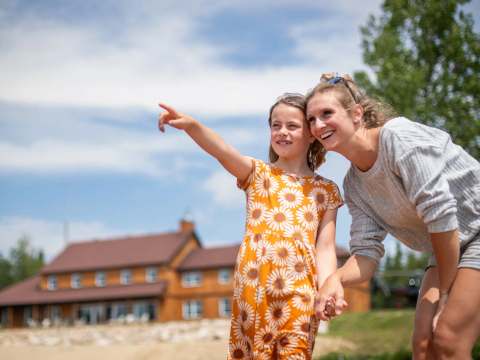 Une mère et sa fille devant l'auberge lors d'un séjour en famille.