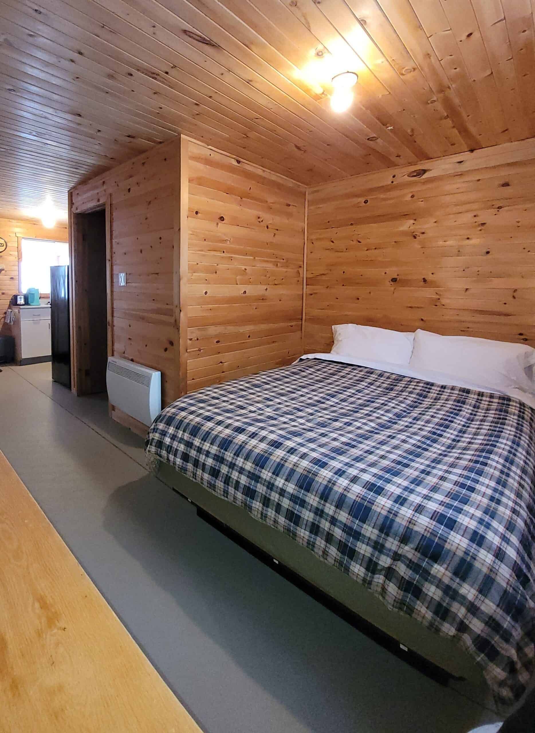 Interior view of the Canard cabin featuring its large bed and adjoining kitchenette area.