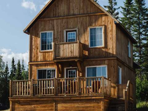 Exterior view of the Colibri cottage with its balcony and wooden deck.