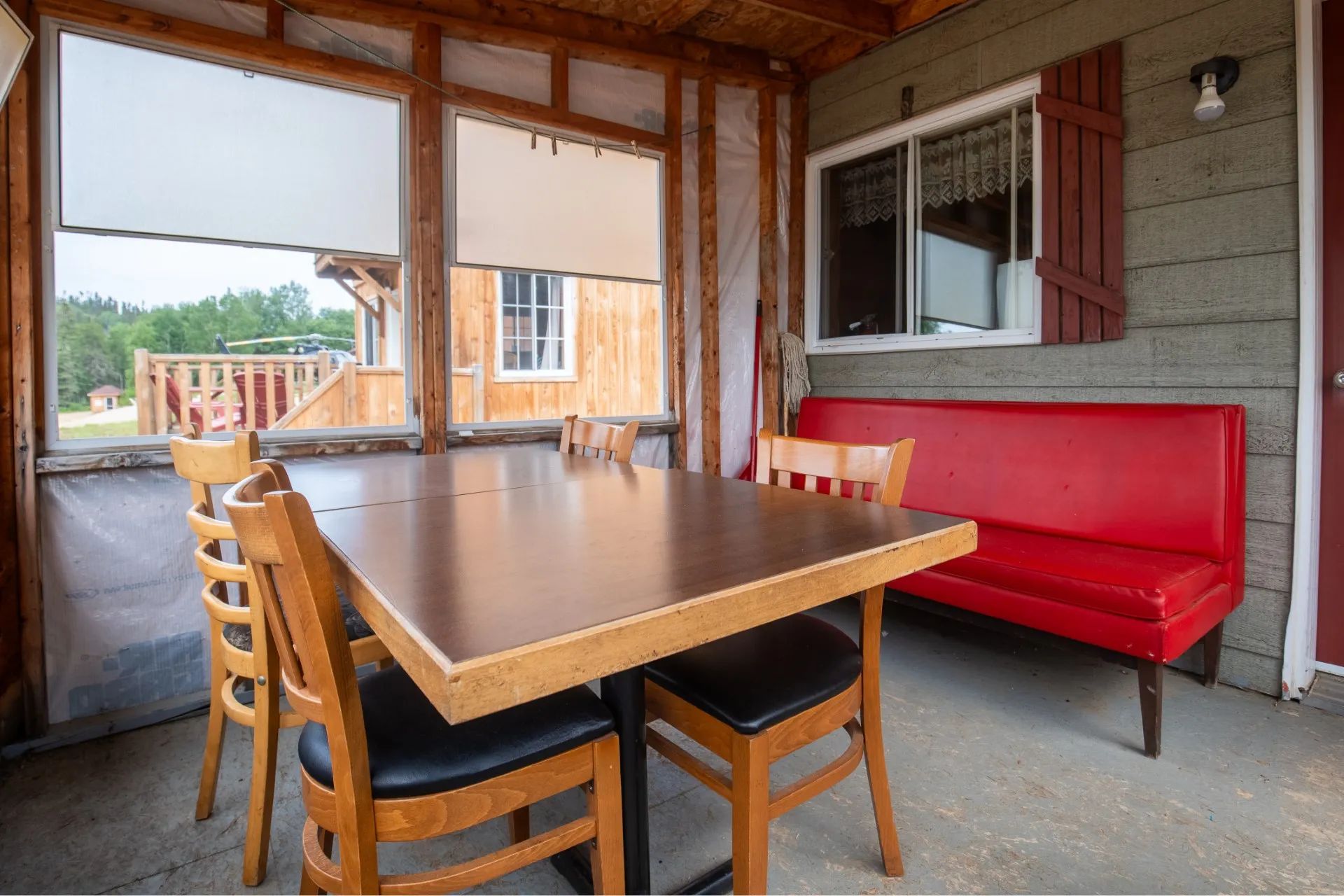 A veranda furnished with a table and a red bench at Auberge Kanawata.